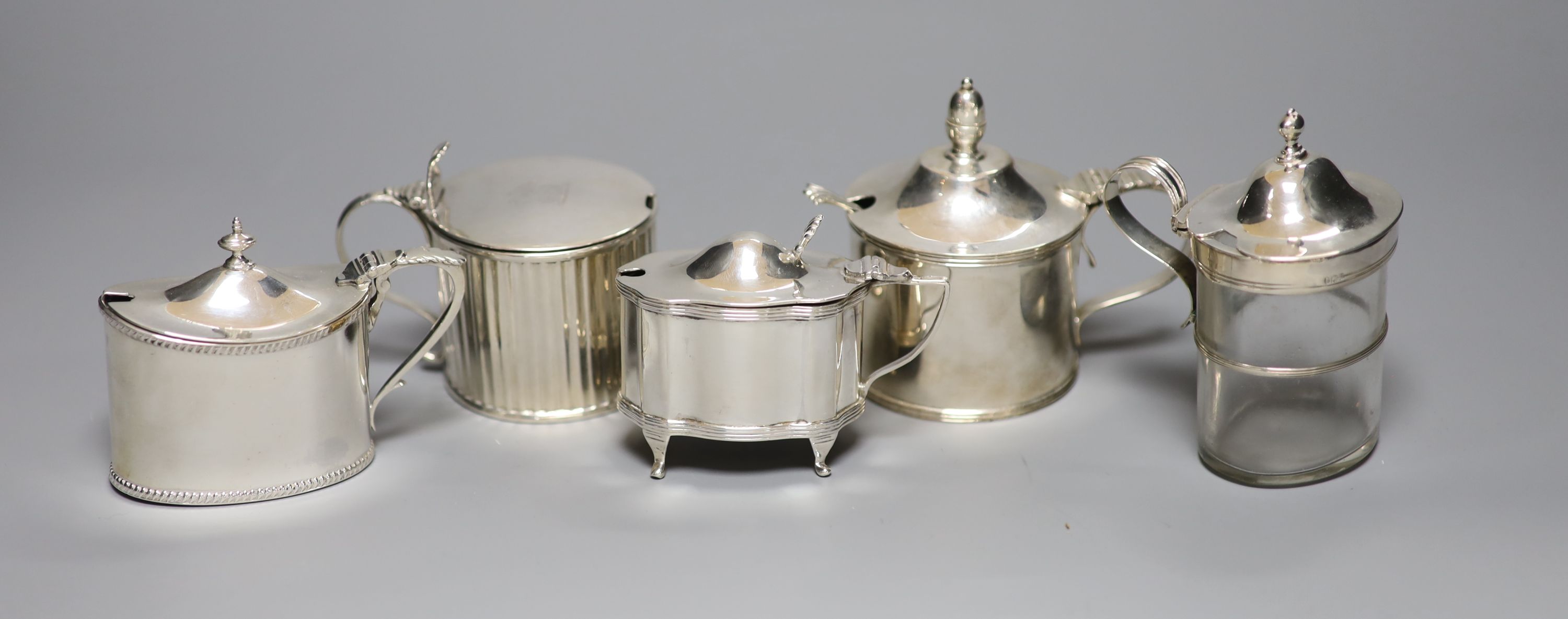 Five mustard pots, various, including a large cylindrical mustard by Mappin & Webb, 1934 Jubilee mark, a similar reeded George III mustard